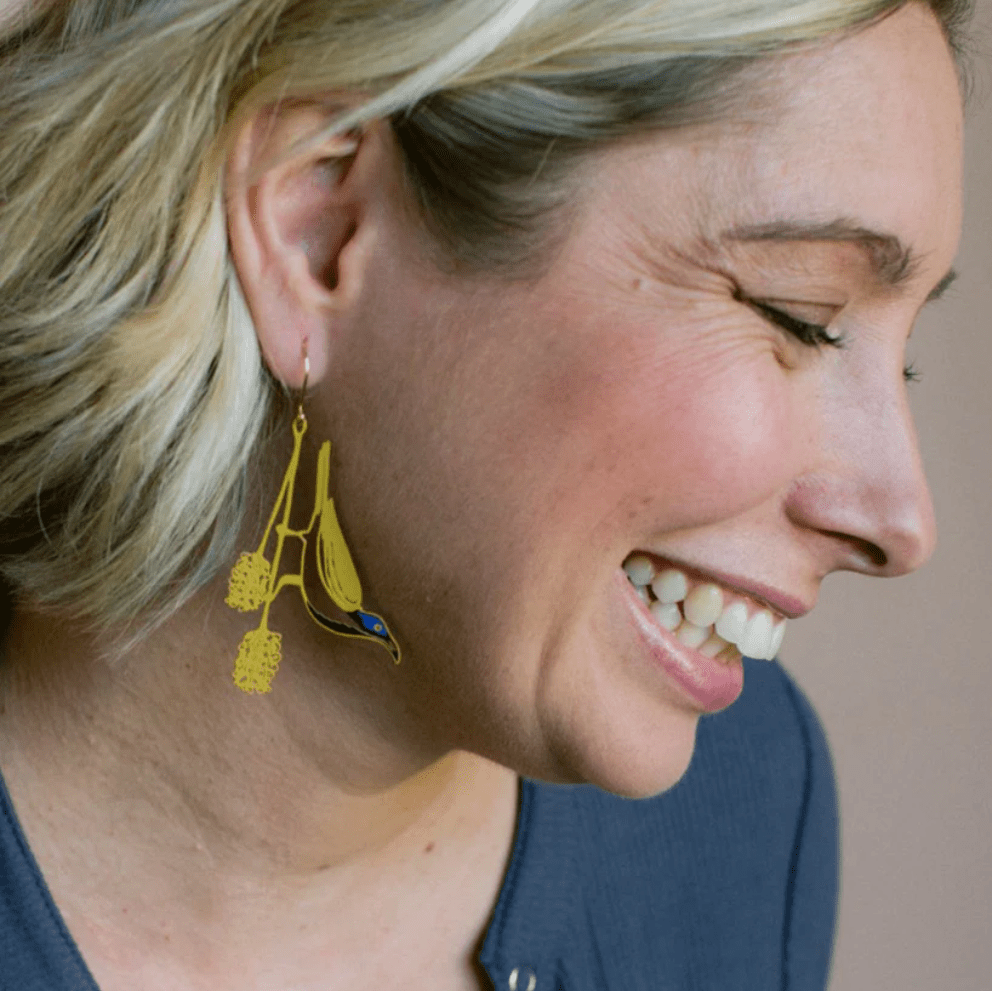 Side profile of a woman wearing DENZ Blue Faced Honeyeater earrings