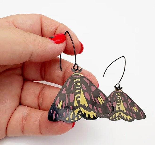 Denz Midi Moth Earrings in Sheep Moth, held by hand