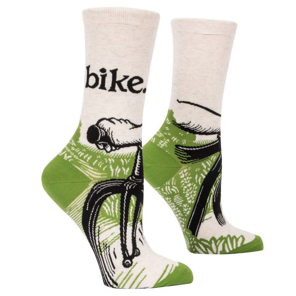A pair of off-white and green Blue Q women's crew socks featuring a bicycle rider's perspective illustration and lower-case black text reading "bike."