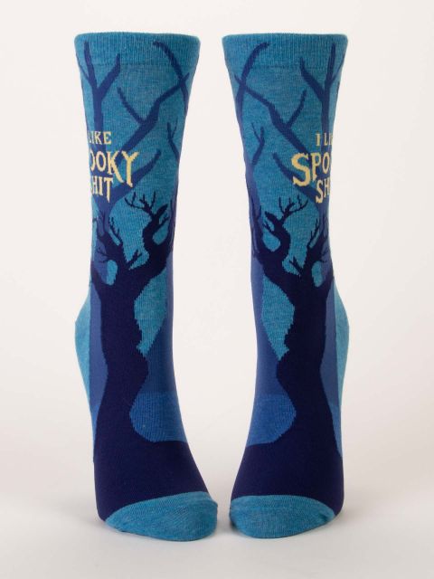 Front view of a pair of blue Blue Q women's crew socks featuring spooky tree silhouettes and yellow text reading "I LIKE SPOOKY SHIT."