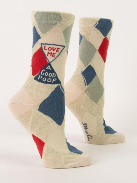 A pair of cream Blue Q women's crew socks featuring a geometric argyle diamond pattern and an hourglass motif reading "LOVE ME A GOOD POOP."