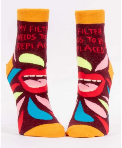 Front-facing studio view of a pair of Blue Q women's burgundy ankle socks with graphic red lips, colorful shapes, and text reading "MY FILTER NEEDS TO BE REPLACED."
