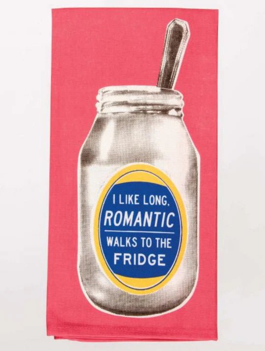 A bright coral pink folded Blue Q tea towel featuring a vintage jar with a spoon and a oval label reading "I LIKE LONG, ROMANTIC WALKS TO THE FRIDGE".