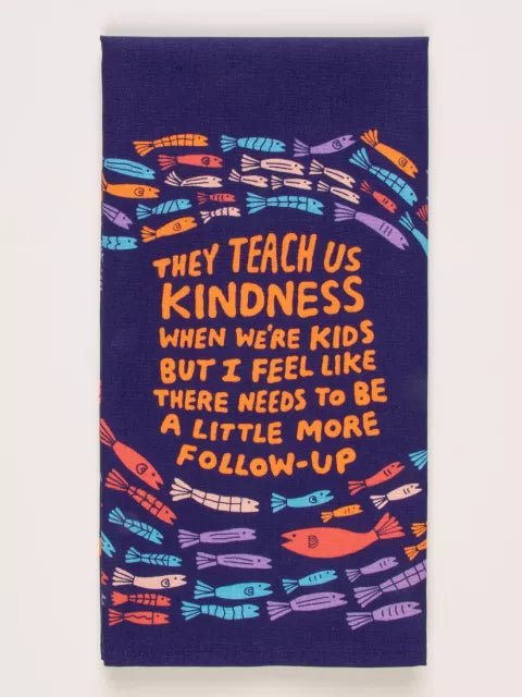 A Blue Q cotton tea towel with a colorful fish pattern and the text 'They teach us kindness when we were kids but I feel there needs to be a little more follow-up' printed on it.