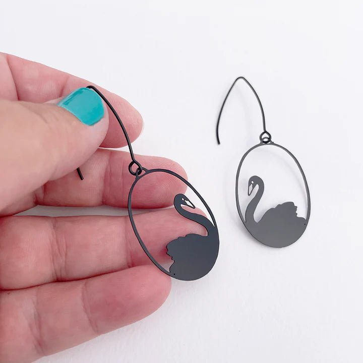 DENZ Mini Black Swans earrings, held by hand
