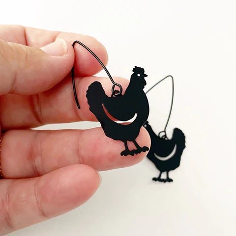 DENZ Mini Chicken dangles in black, held by hand