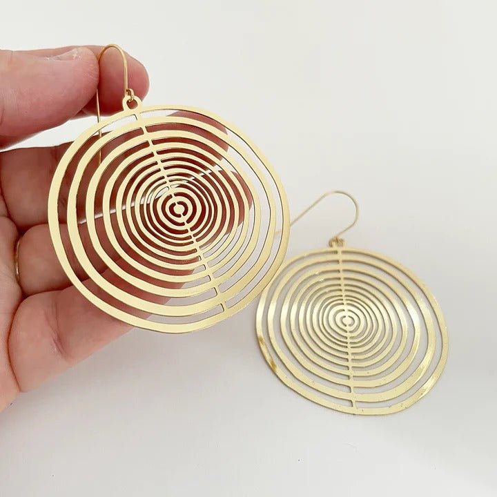 DENZ Orbit (flat) dangles in gold, held by hand