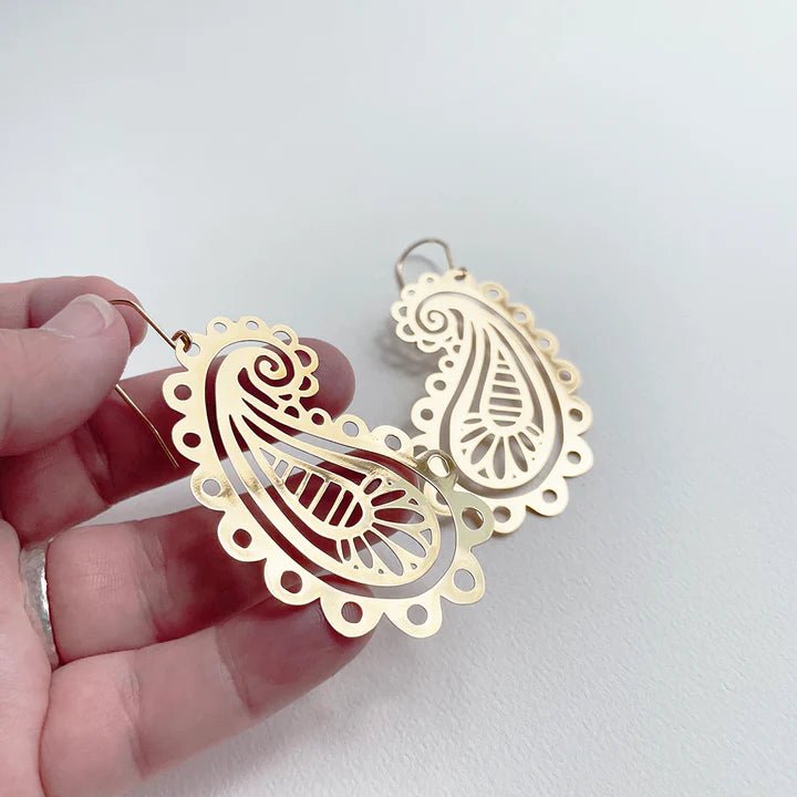 DENZ Paisley dangles in gold, held by hand