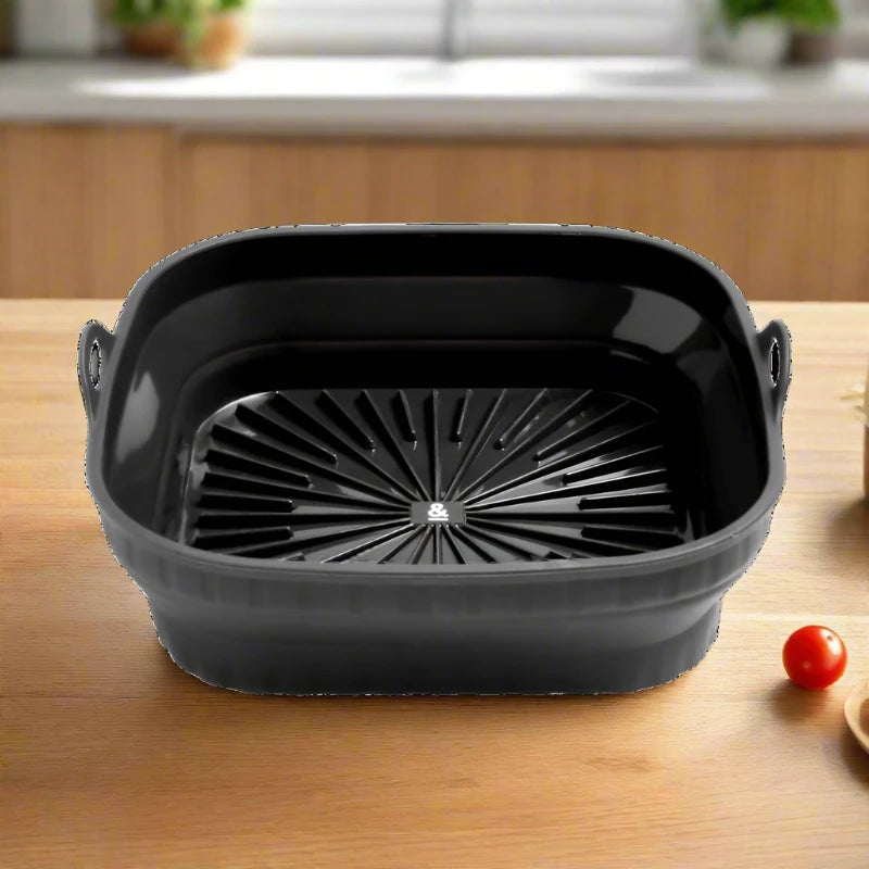 Seed & Sprout square silicone air fryer bowl in liquorice black, featuring integrated side handles and a ribbed base for enhanced airflow.