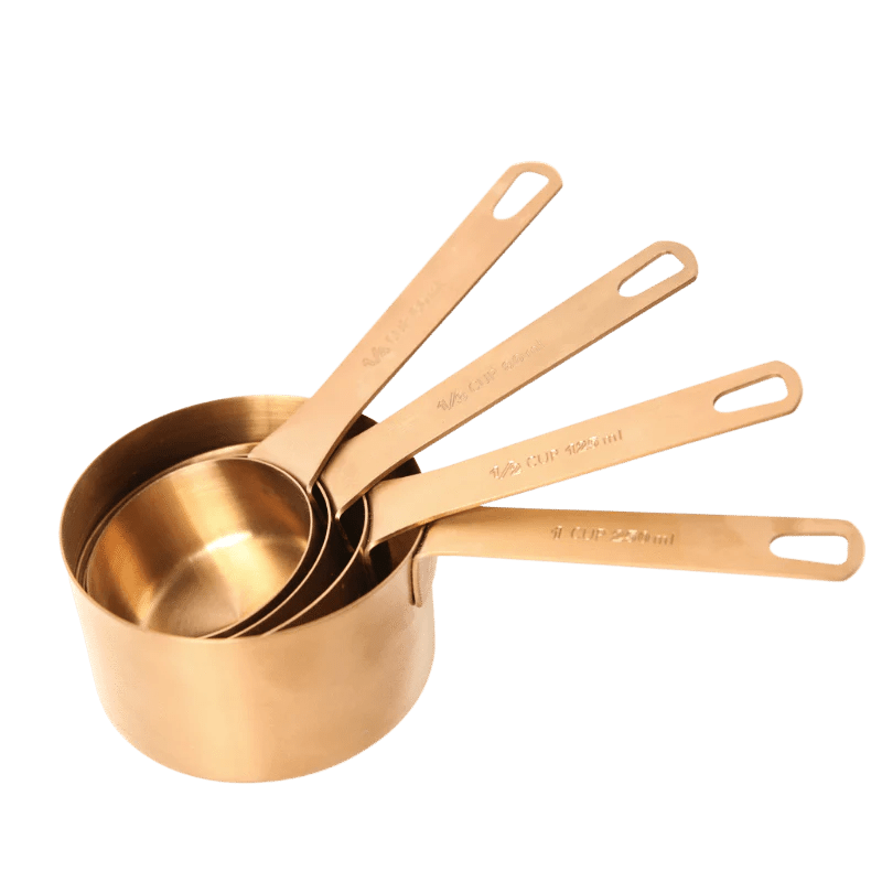 Seed & Sprout stainless steel measuring cup set of four in a warm bronze finish, featuring engraved volume measurements.