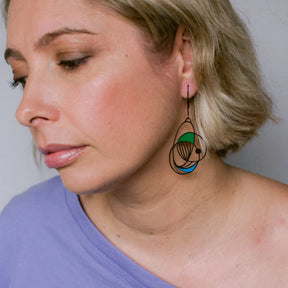 Close-up of a woman wearing a DENZ Art School Drop Out Earrings in Cool unique with a colorful design.