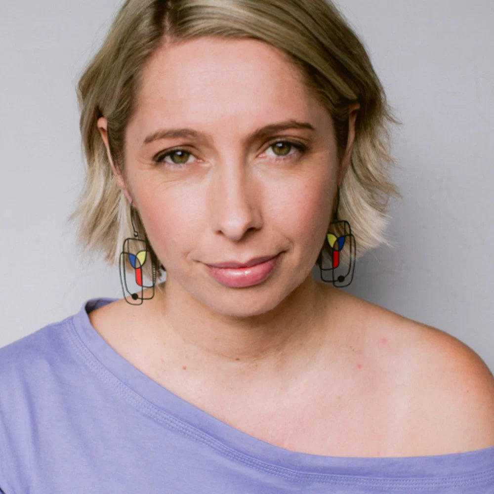 Woman wearing DENZ Art School Drop Out Earrings in Primary against a plain background