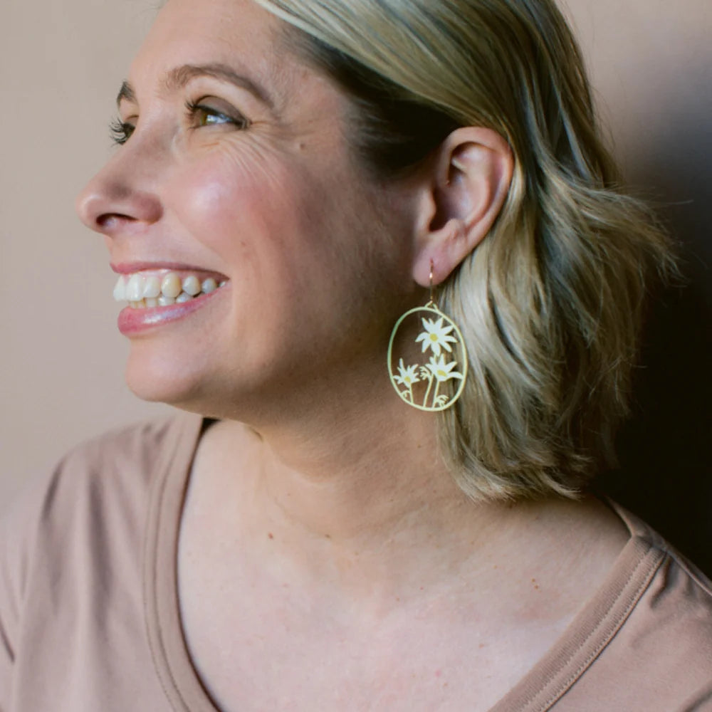 Woman wearing a Flannel Flower earrings in Lemon & Cream against a neutral background