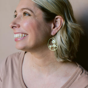Woman wearing a Flannel Flower earrings in Lemon & Cream against a neutral background