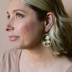 Woman wearing a Flannel Flower earrings in Lemon & Cream with a neutral background