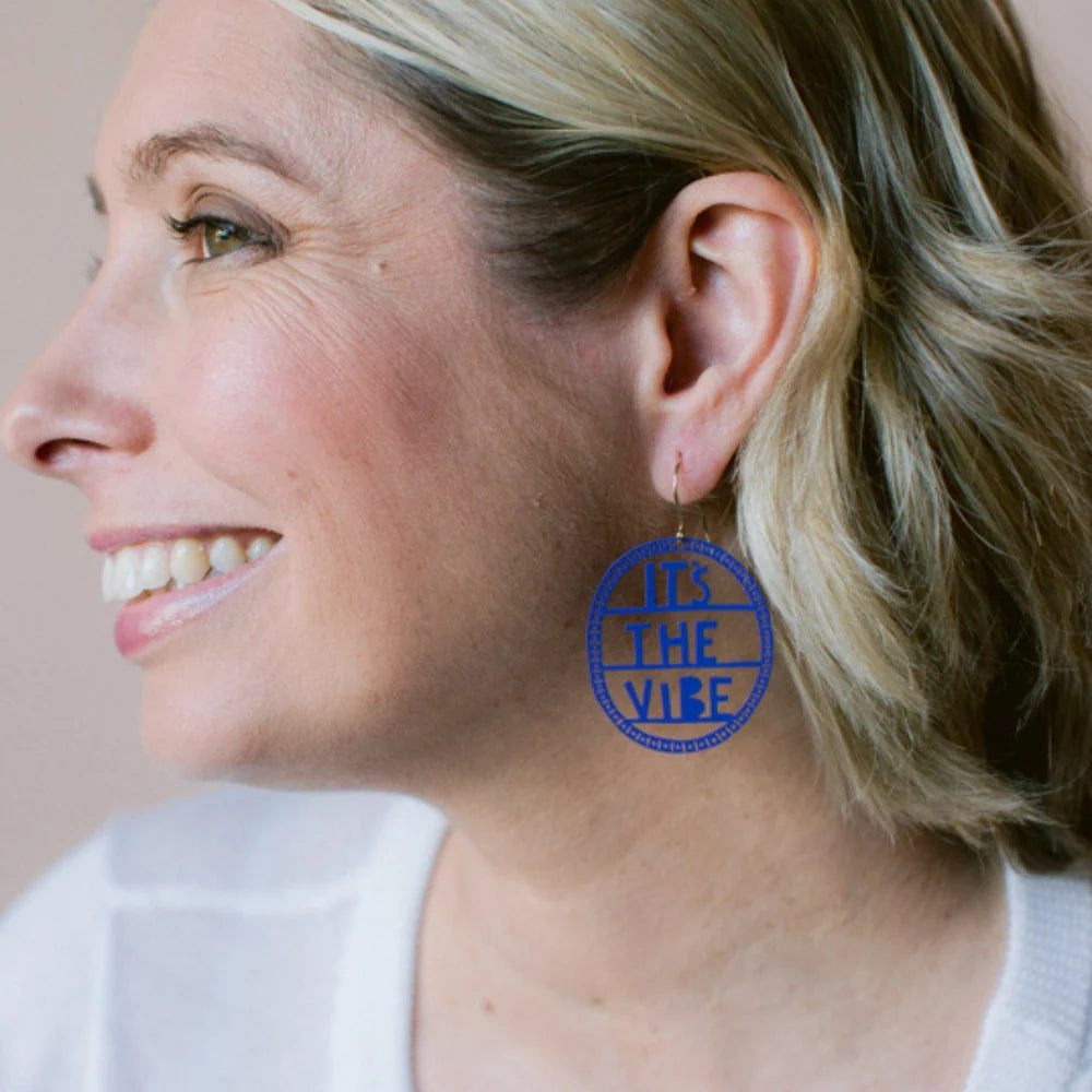 Woman wearing a DENZ Indigo earring with 'It's The Vice' text