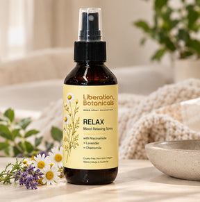Liberation Botanicals Relax Mood Relaxing Spray 100mL with niacinamide, lavender, and chamomile styled in a cozy setting.