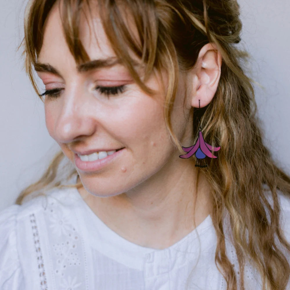 Woman wearing colorful DENZ Fuchsia Flower Earrings with a neutral background