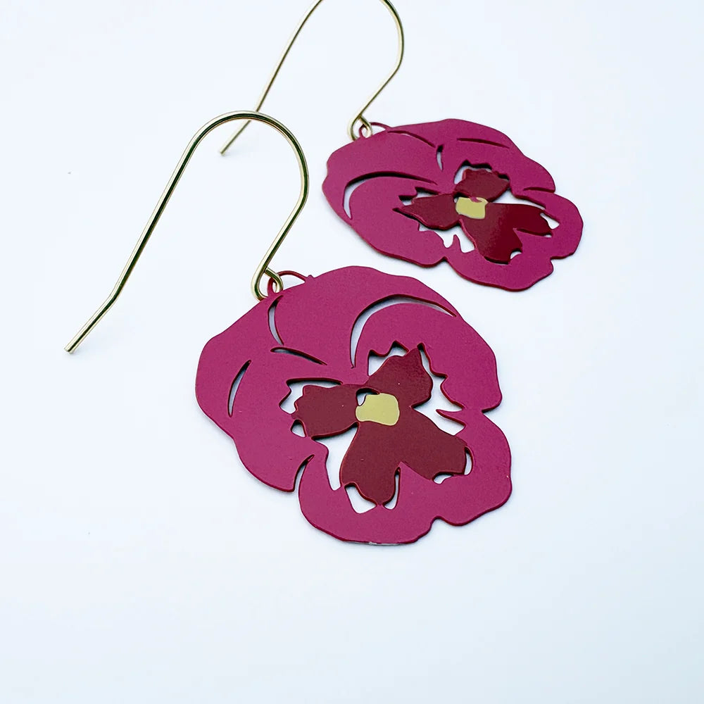 A pair of DENZ Pansy Flower earrings with magenta-pink laser-cut flower shapes and gold-tone fishhook wires, displayed on a clean white background.
