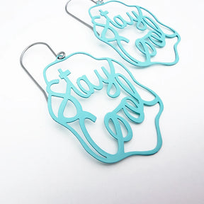 A pair of DENZ mintblue laser-cut dangle earrings with silver-tone fishhook wires, featuring the phrase 'stay open' in cursive script, displayed on a clean white background.