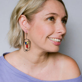 Side profile of a woman wearing DENZ Art School Drop Out Earrings in Primary 