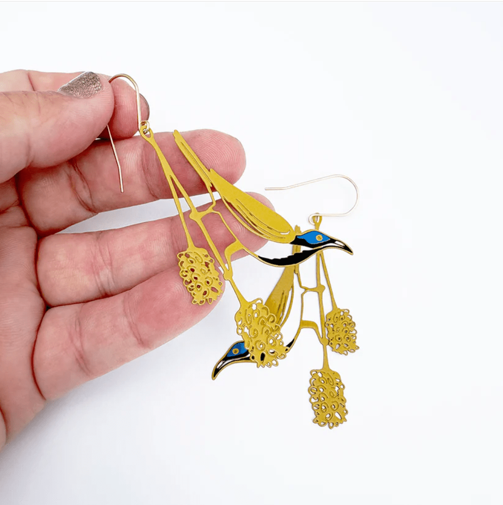 DENZ Blue Faced Honeyeater earrings, held by hand