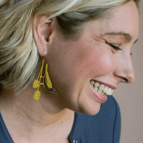 Side profile of a woman wearing DENZ Blue Faced Honeyeater earrings 