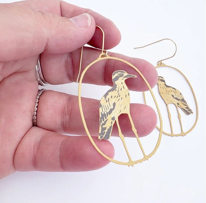 Denz Bush Stone Curlew earrings in Brown, held by hand