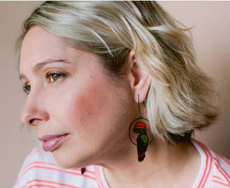 Side profile of a woman wearing Denz Christmas Red Tailed Cockatoos in Black/Red/Yellow 