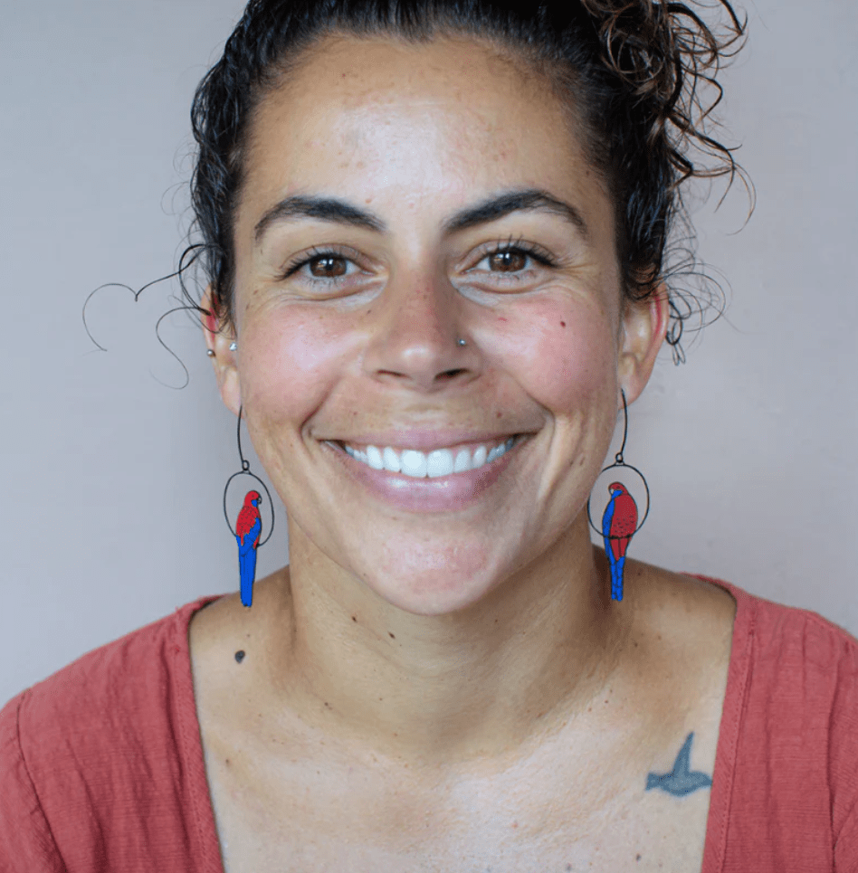 Woman is wearing the DENZ Crimson Rosella earrings