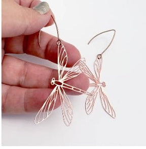 Denz Dragonfly Earrings in Rose Gold, held by hand