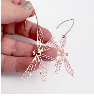 Denz Dragonfly Earrings in Rose Gold, held by hand