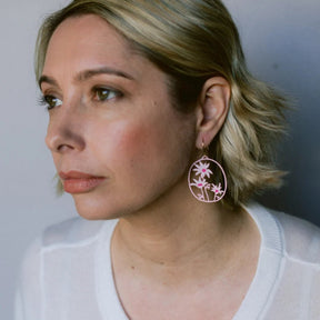 A woman on white top is wearing DENZ Flannel Flower Earrings in Pinks & White 