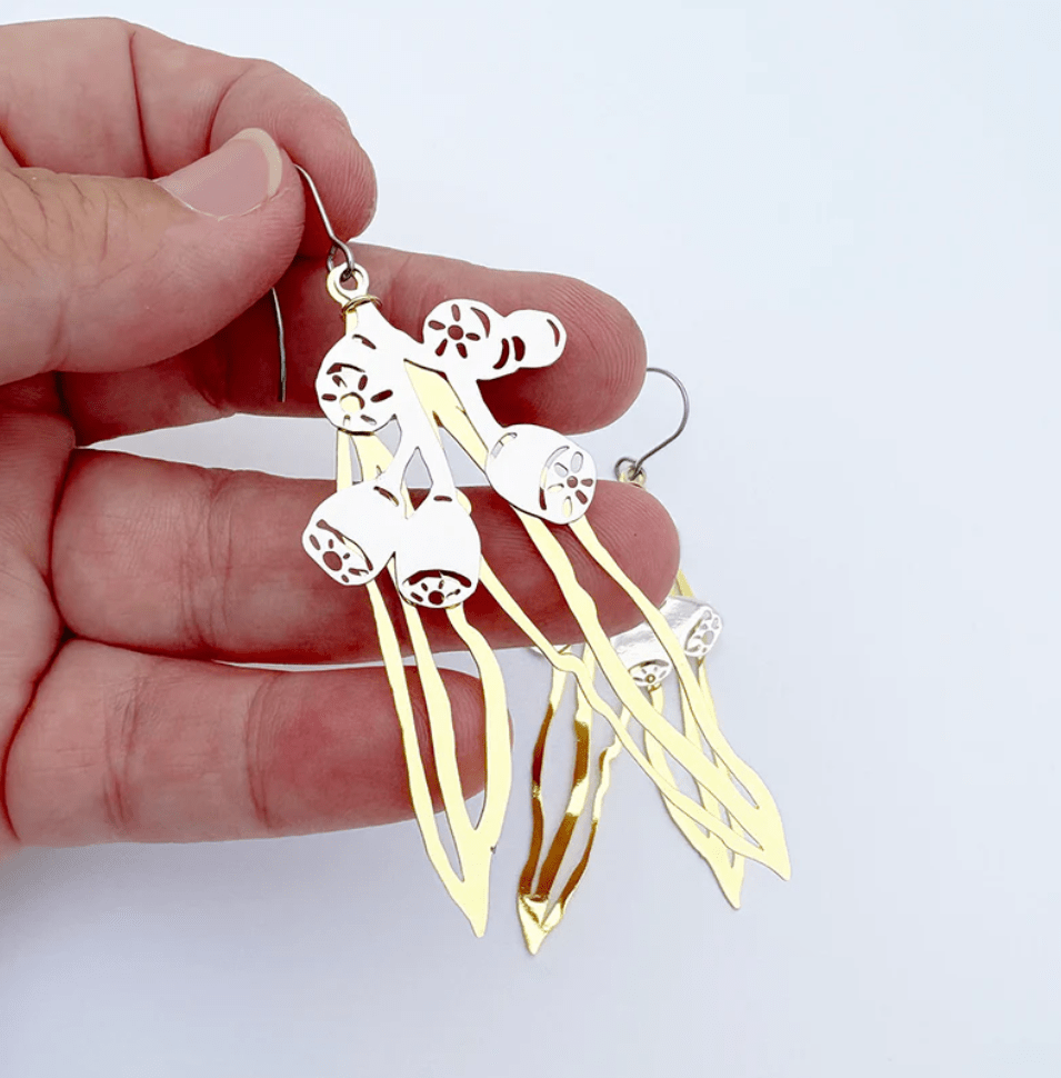 DENZ Gumnut & Leaf dangle earrings in Gold/Silver, held by hand