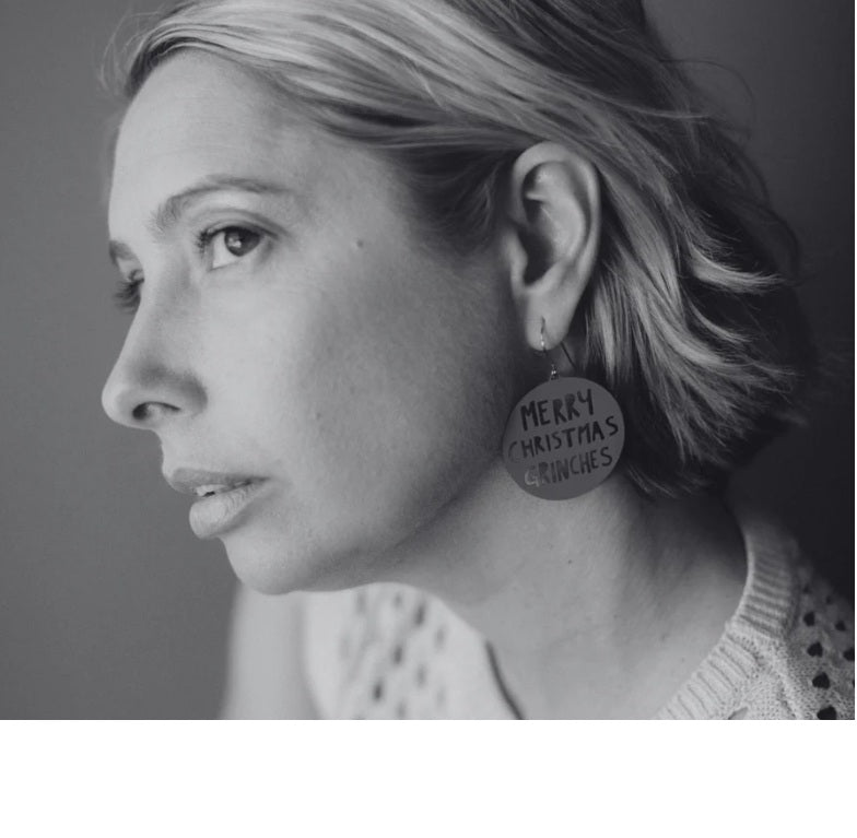 Side profile of a woman wearing Denz Merry Christmas Grinches Earrings in Red