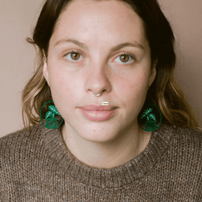 Woman wearing the DENZ Midi Alocasia plant earrings in Green/White 