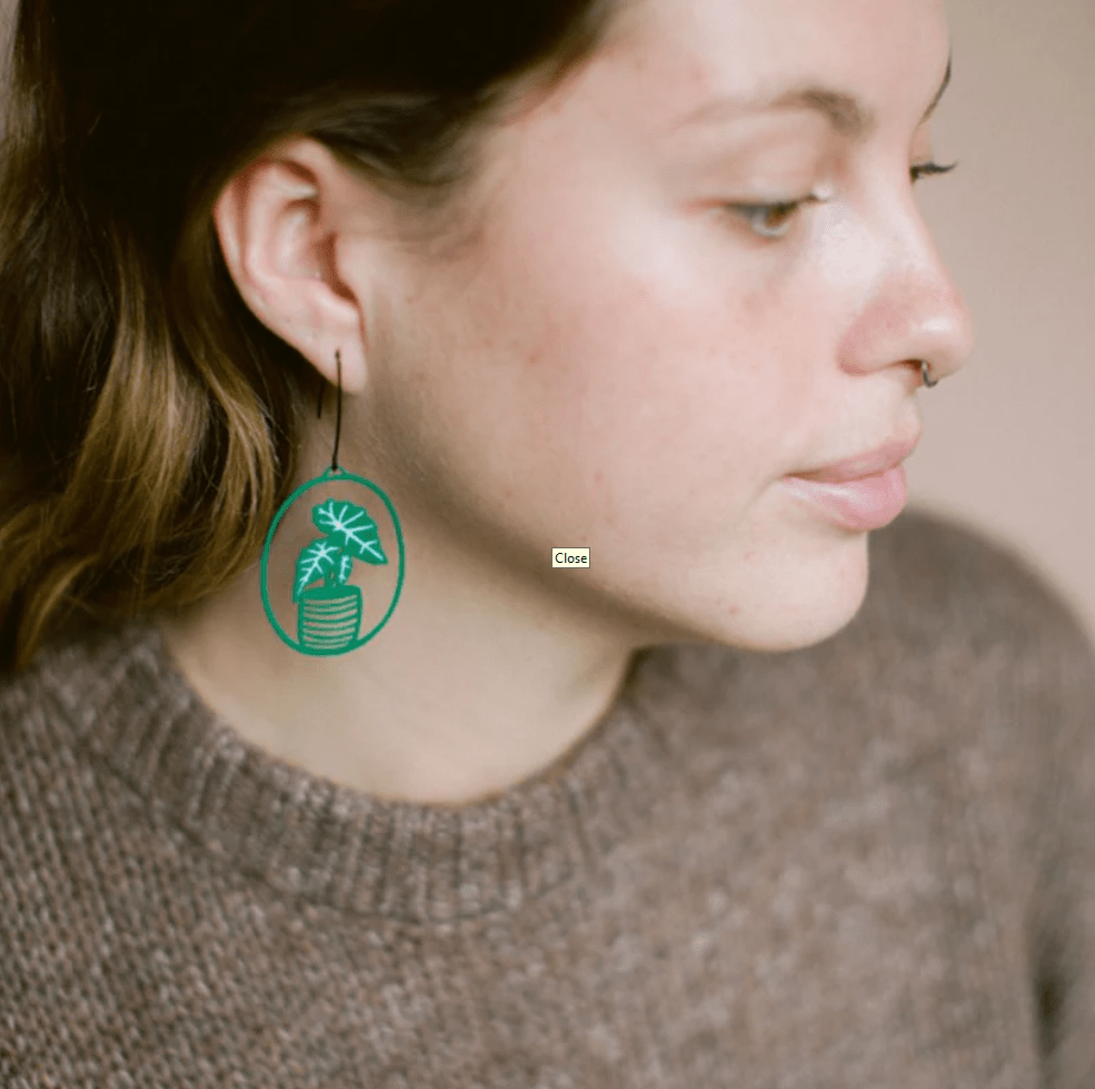Close-up profile of a woman DENZ Midi Alocasia plant earrings in Green/White 