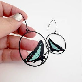 Denz Midi Butterfly Earrings in Blue Triangle, held by hand