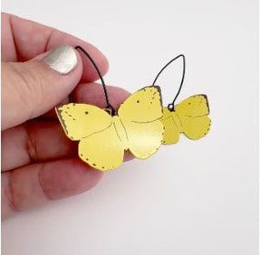 Denz Midi Butterfly Earrings in Lemon Migrant, held by hand