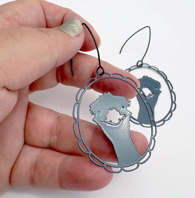 Denz Midi Emu Earrings in Grey/Blue, held by hand