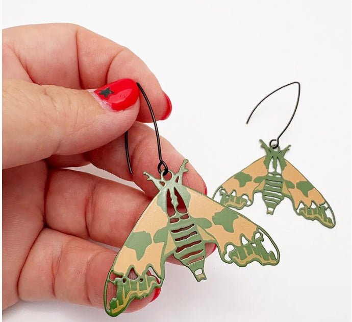 Denz Midi Moth Earrings in Lime Hawk, held by hand