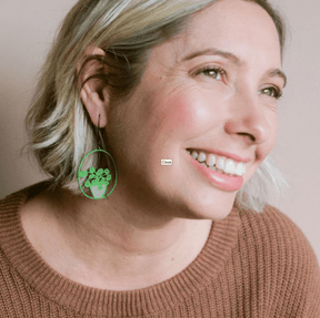 Side profile of a woman wearing thre DENZ Midi Pilea plant earrings in Bright Green/Pink 