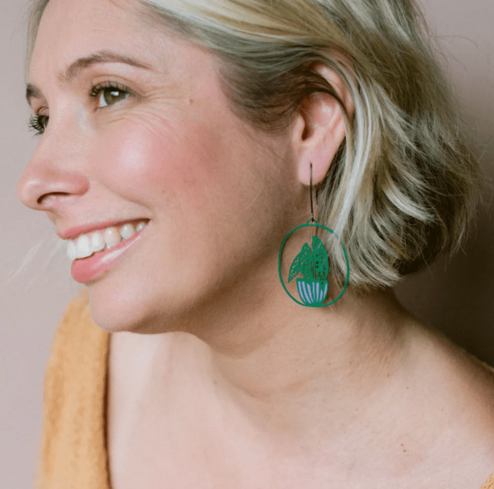 Side profile of a woman wearing DENZ Midi Spotted Begonia plant earrings in Dark Green/Purple 