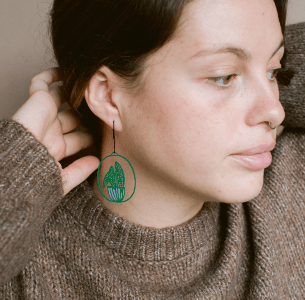 Woman wearing the DENZ Midi Spotted Begonia plant earrings in Dark Green/Purple 