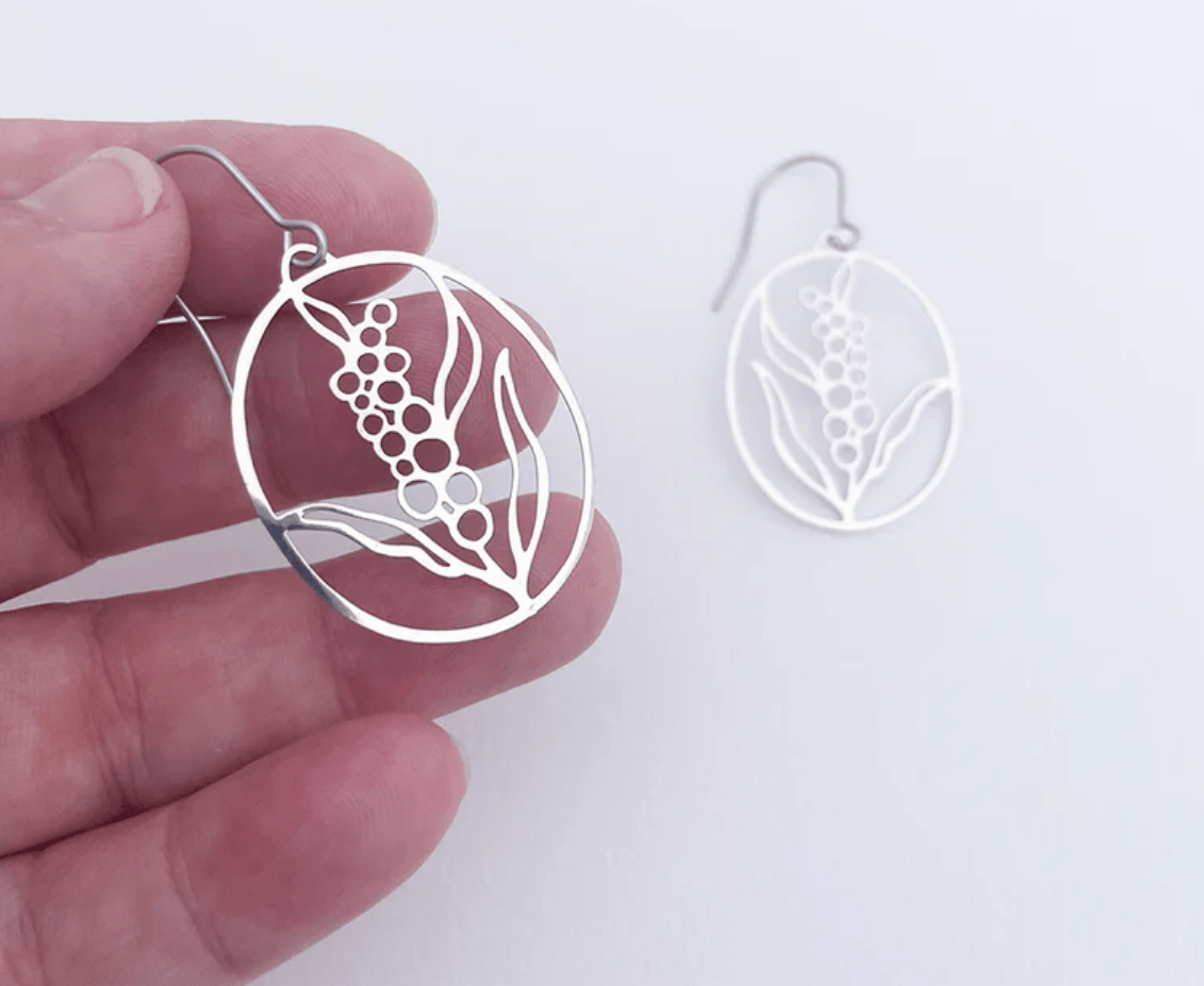 DENZ Mini Wattle Flower earrings in Silver, held by hand