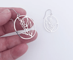 DENZ Mini Wattle Flower earrings in Silver, held by hand