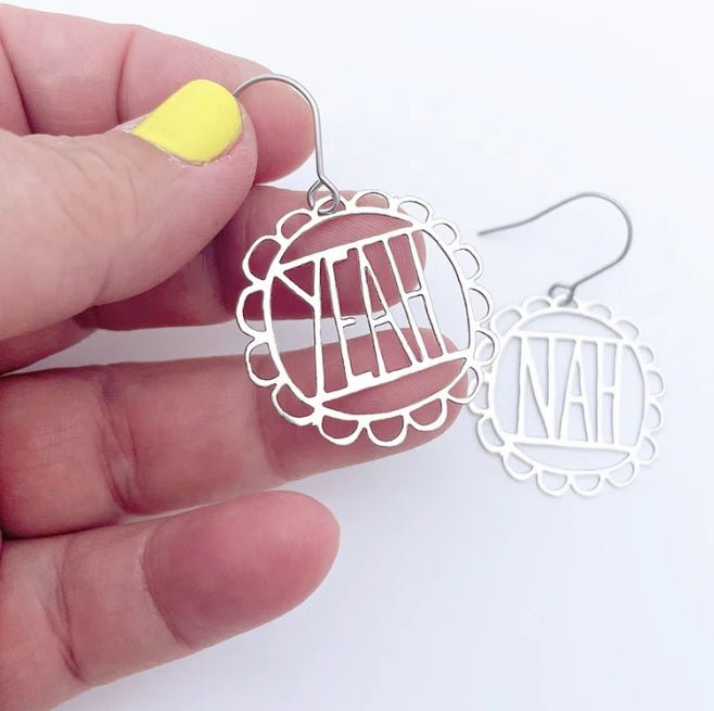Denz Mini YEAH/NAH Earrings in Silver, held by hand