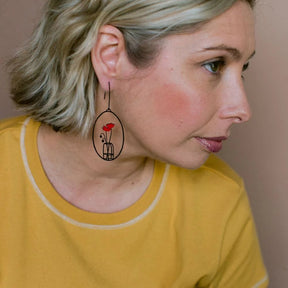 Woman in a yellow top wearing DENZ Poppy Vase Earrings in Black & Red 