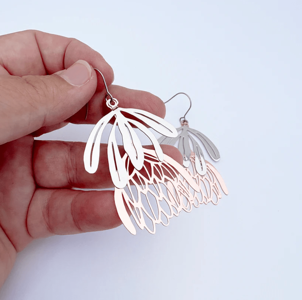 DENZ Protea flower dangle earrings in Silver/Rose Gold, held by hand