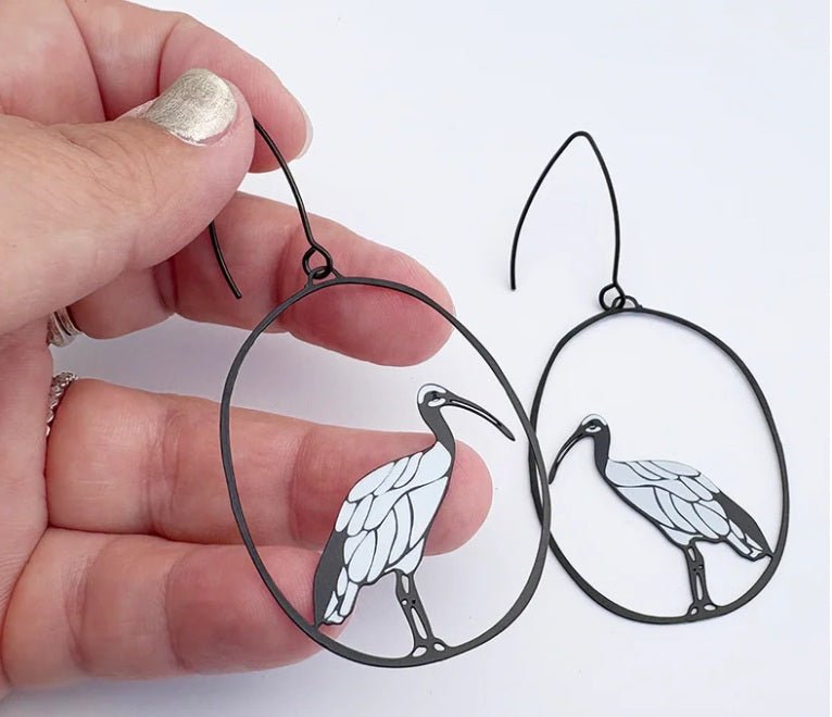 Denz Sacred Ibis Earrings in Black/White, held by hand